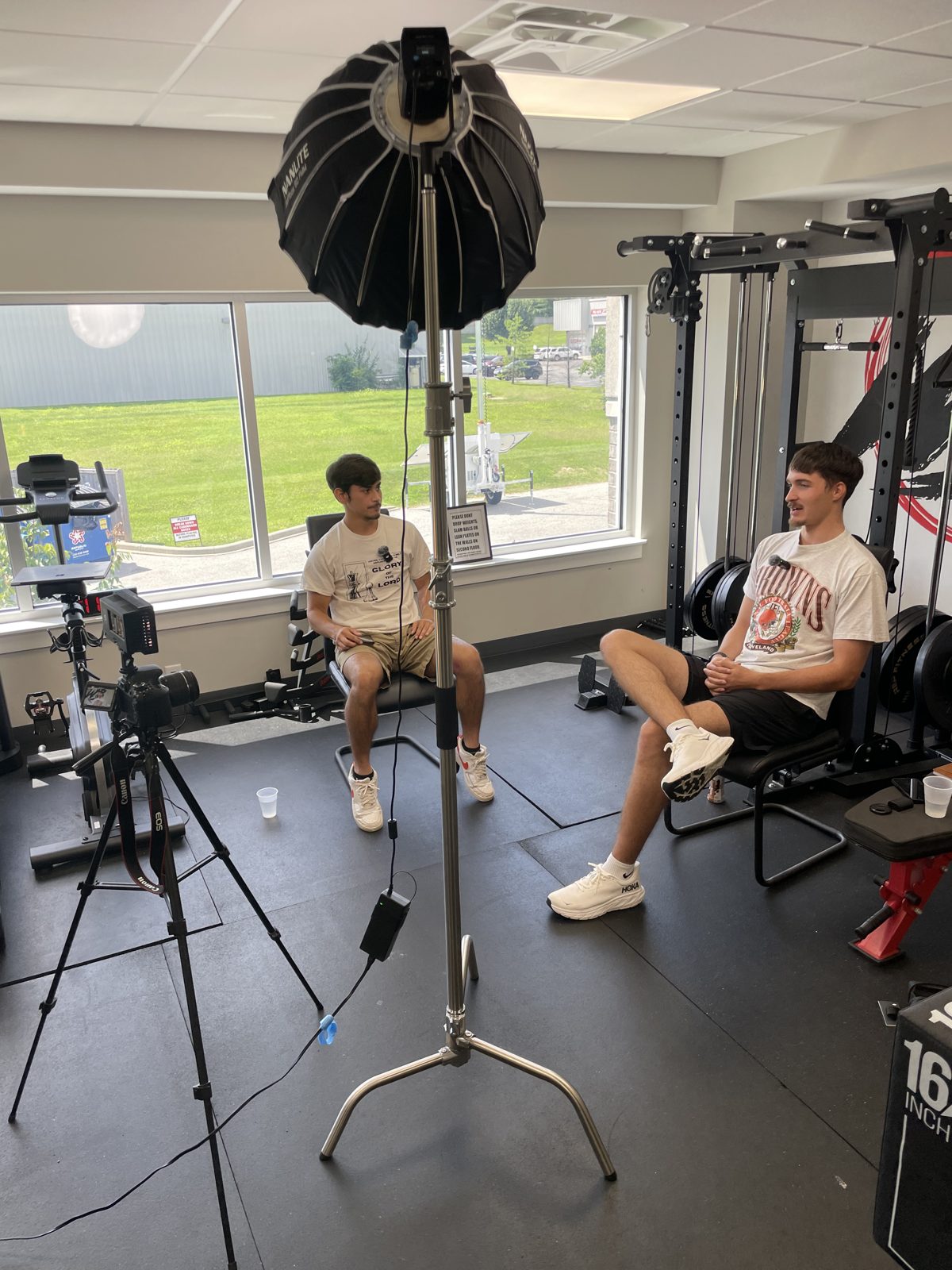 Two-person interview setup with softbox lighting and cinema camera on location